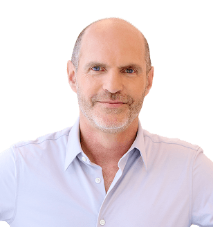 Portrait of a smiling middle-aged man with short gray stubble, wearing a light blue button-down shirt.