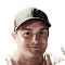 Close-up of a man wearing a dark baseball cap, smiling at the camera.